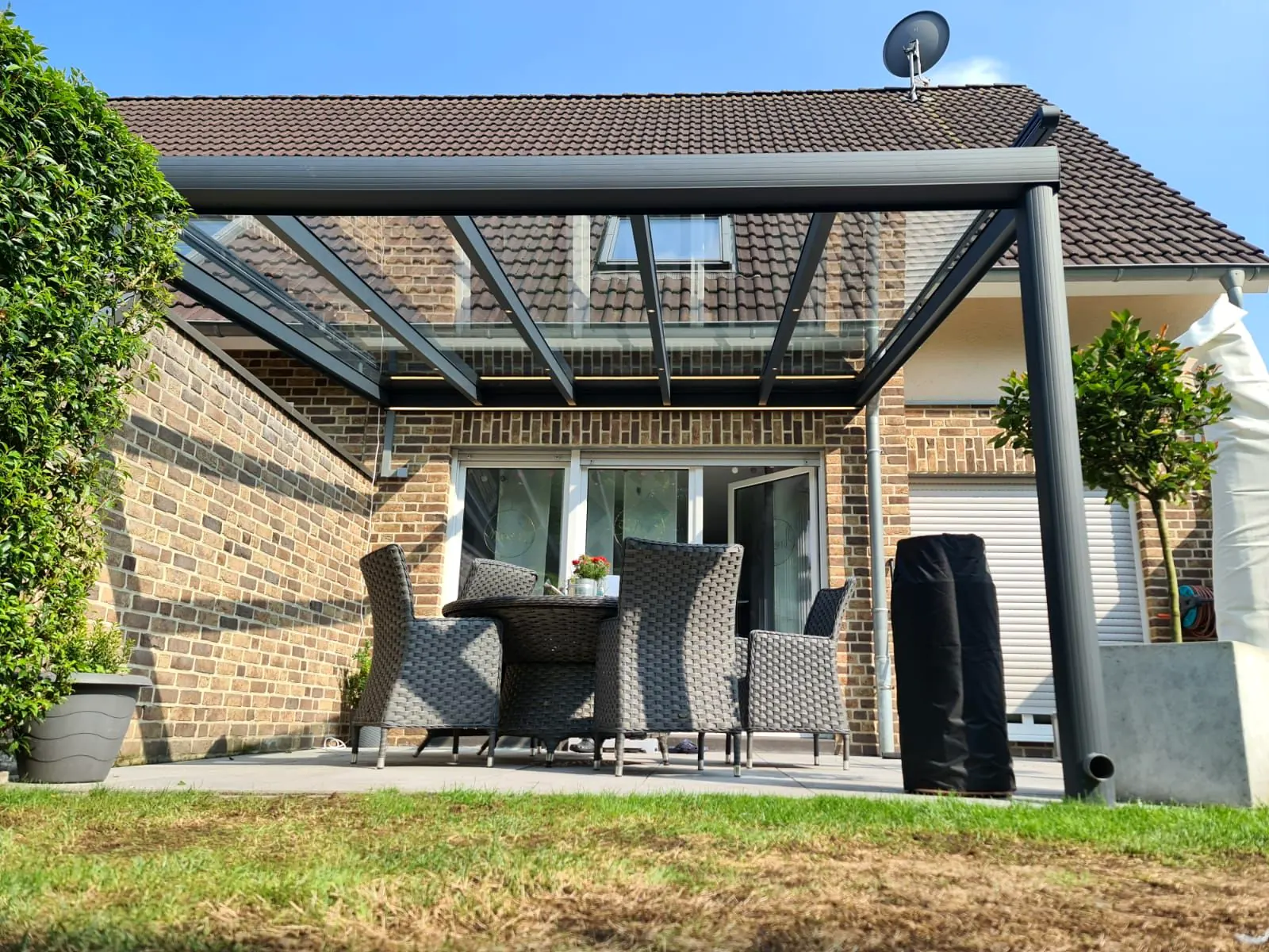 Terrassenüberdachung aus Aluminium mit Glasdach im Garten