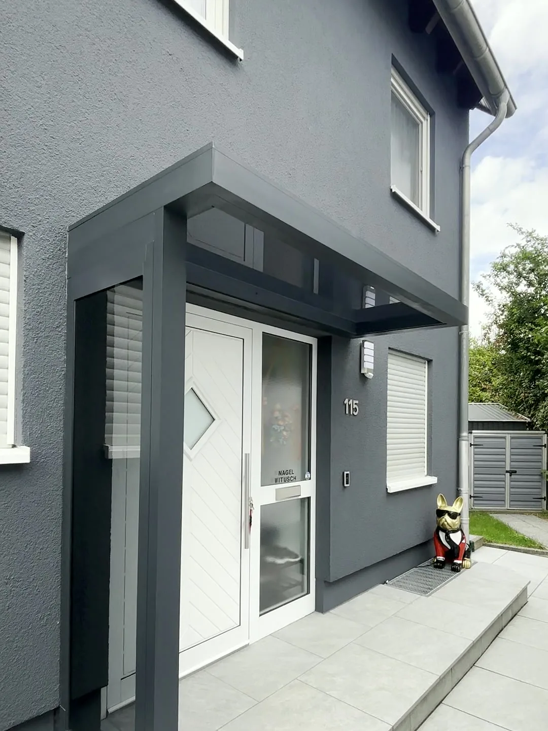 Vordach mit Glas-Seitenwand als Wind- und Regenschutz am Hauseingang
